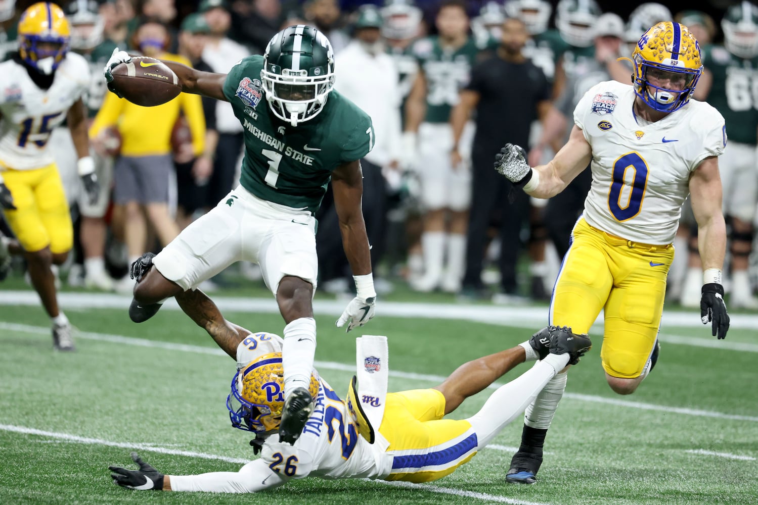 Michigan State Spartans wide receiver Jayden Reed (1) jumps to elude the tackle of Pittsburgh Panthers defensive back Judson Tallandier (26) on a punt return by Reed during the first half of the Chick-fil-A Peach Bowl at Mercedes-Benz Stadium in Atlanta, Thursday, December 30, 2021. JASON GETZ FOR THE ATLANTA JOURNAL-CONSTITUTION