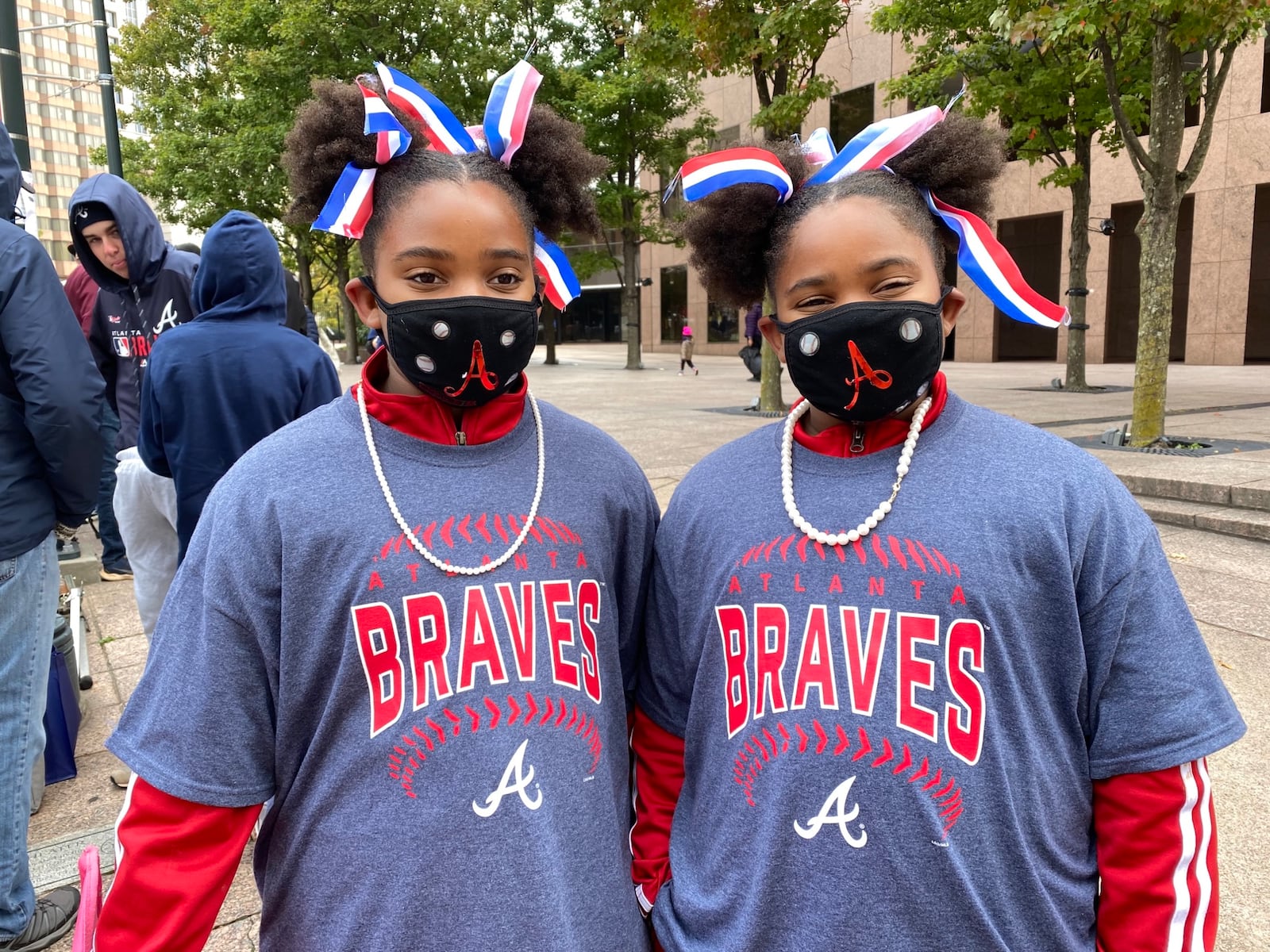 Abygail and Asylee Robinson, 10-year-old twins from Lawrenceville, said they likely would have been taking a reading test if their Gwinnett school hadn’t been cancelled for the Braves parade. Their grandmother bedazzled their custom masks for the event. VANESSA McCRAY/ AJC