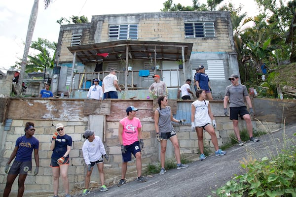 Georgia Tech athletes on a service trip to Vega Alta, Puerto Rico, form a bucket brigade as they worked to construct a concrete barrier in front of the home to protect it from storms. (Brad Malone/Georgia Tech Athletics)