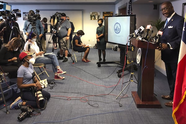 Atlanta Journal-Constitution staff photojournalist Alyssa Pointer, left, works during a news conference, Tuesday, June 2, 2020, in Atlanta. Pointer was detained by officers of the Georgia Department of Natural Resources during a protest in downtown. Pointer said her press badge was clearly displayed, and she identified herself to law enforcement. (AP Photo/Kate Brumback)