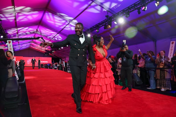 Delta honoree Kelvin Sharpe walks down the red carpet with his wife Lakeisha Sharpe during the 2024 Delta Chairman’s Club Gala at the Delta Flight Museum on Nov. 21 in Atlanta. (Jason Getz/AJC)
