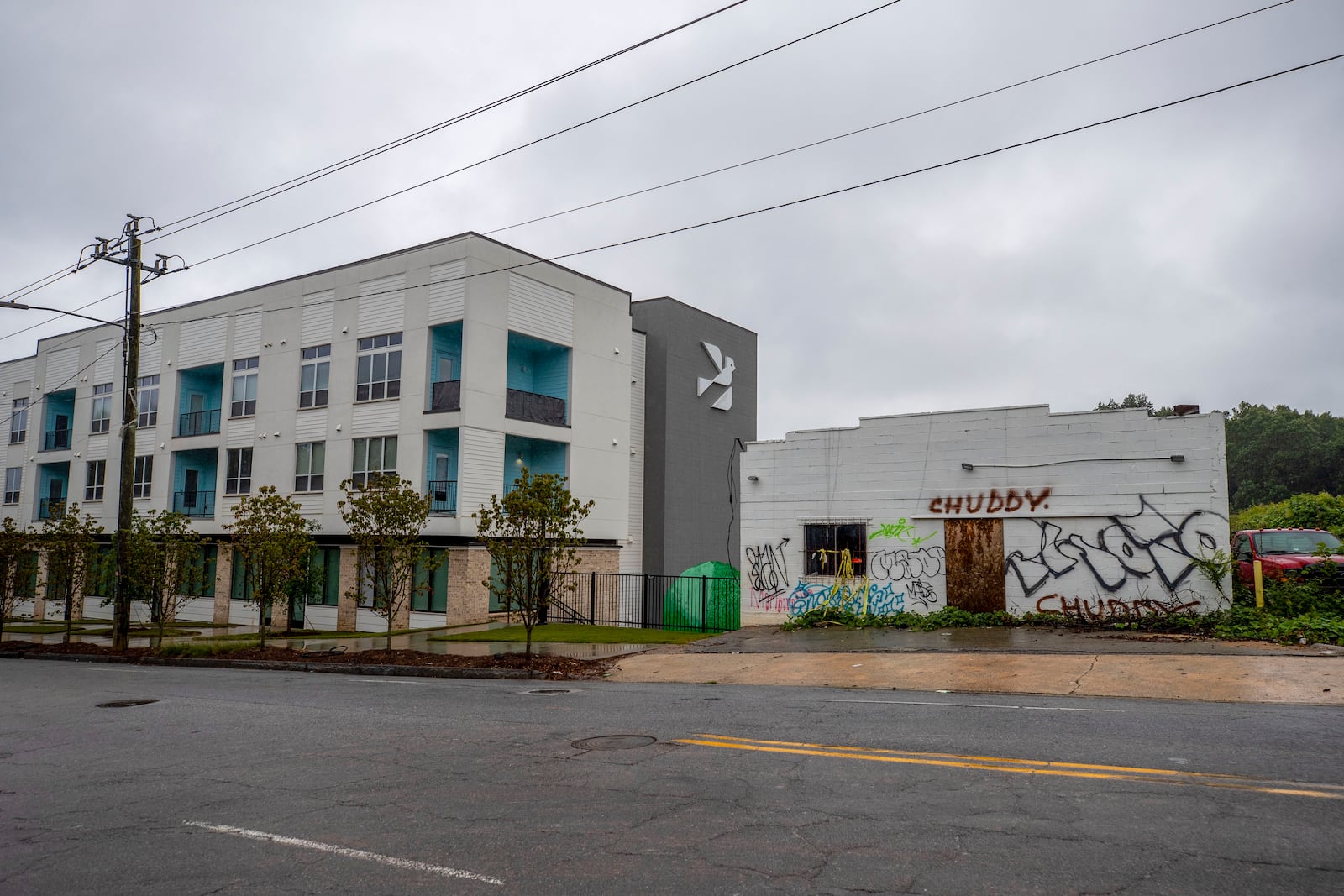 Up the street from the Gladstone Apartments, an abandoned building sits near a new complex. (Alyssa Pointer / Alyssa.Pointer@ajc.com)