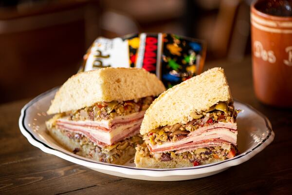 Muffuletta with salami, capicola, mortadella, provolone, olive relish, vinaigrette, classic sesame bread and a bag of Zapp's chips. Photo credit- Mia Yakel.