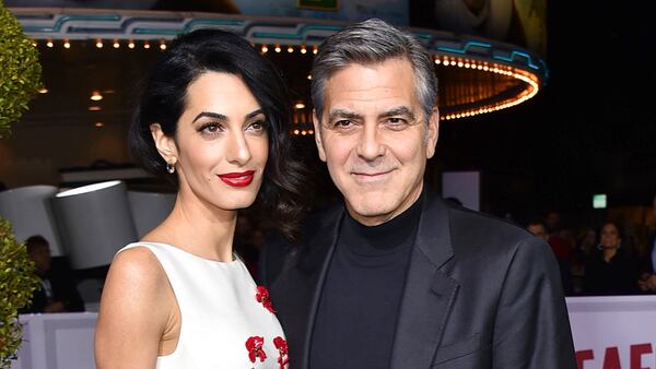 FILE - In this Feb. 1, 2016 file photo, Amal Clooney, left, and George Clooney arrive at the world premiere of "Hail, Caesar!" in Los Angeles.  George and Amal Clooney have welcomed twins Ella and Alexander Clooney. The pair was born Tuesday morning, June 6, 2017, according to George Clooney's publicist Stan Rosenfield.  (Photo by Jordan Strauss/Invision/AP, File)