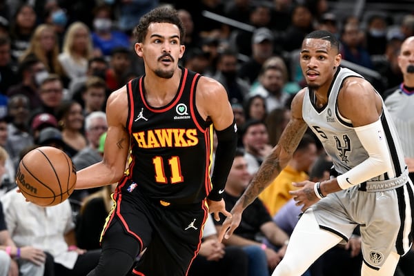 Atlanta Hawks' Trae Young (11) drives past San Antonio Spurs' Dejounte Murray during the first half of an NBA basketball game, Wednesday, Nov. 24, 2021, in San Antonio. Now they will be teammates. (AP Photo/Darren Abate)