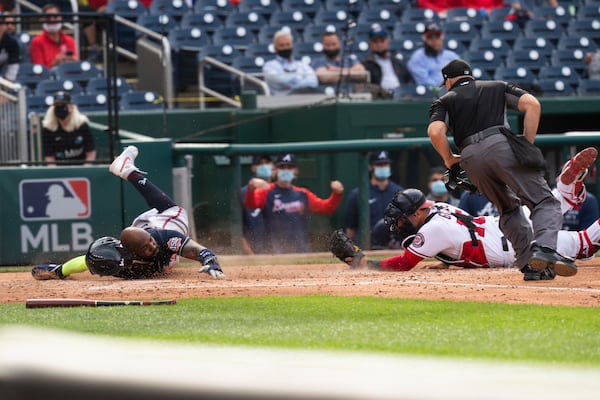 Atlanta Braves' Marcell Ozuna, left, slides safely into home as Washington Nationals' catcher Yan Gomes (10) tries a tag during the fourth inning of a baseball game against in Washington, Thursday, May 6, 2021. (AP Photo/Manuel Balce Ceneta)