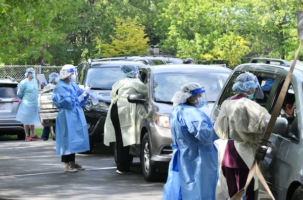 Health care workers help Hall County residents get tested at a drive-through COVID-19 testing sites in Gainesville in April 2020. (Hyosub Shin / Hyosub.Shin@ajc.com)