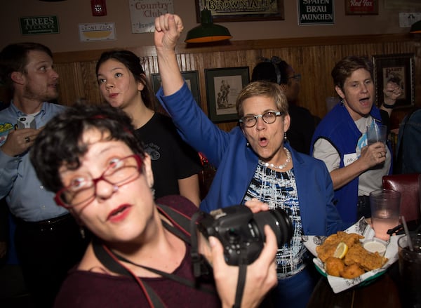 Atlanta mayoral candidate Cathy Woolard cheers as she sees the early returns flash up on the TV at Six Feet Under.