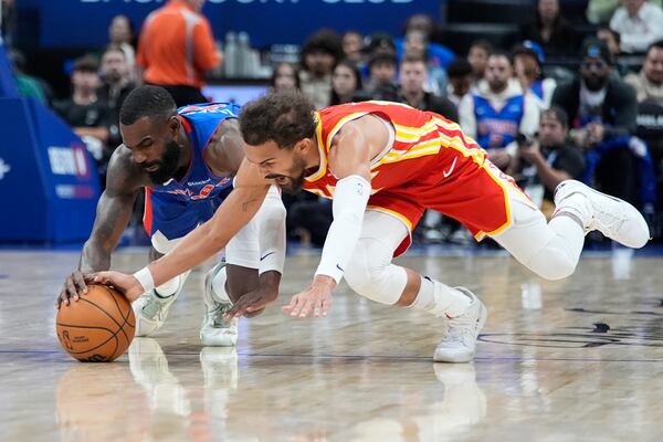 Detroit Pistons forward Tim Hardaway Jr., left, and Atlanta Hawks guard Trae Young reach for the loose ball during the first half of an NBA basketball game, Friday, Nov. 8, 2024, in Detroit. (AP Photo/Carlos Osorio)