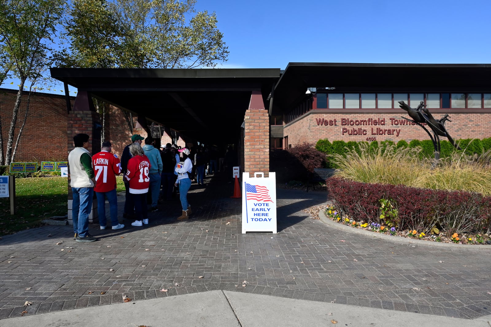 Early voters line up out the front door of the West Bloomfield Township Public Library to cast a ballot, Sunday, Oct. 27, 2024, in West Bloomfield Township, Mich. (AP Photo/Jose Juarez)