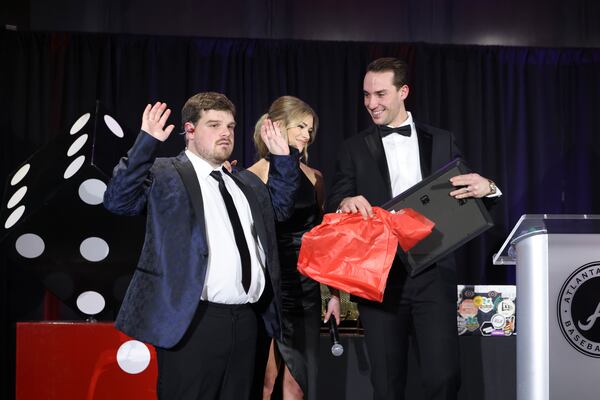 Atlanta Braves first baseman Matt Olson and his wife Nicole react as they receive a gift from Reece Blankenship during Diamond Casino Night at the Delta Club in Truist Park, Friday, January 27, 2023, in Atlanta. Reece Blankenship is a non-verbal autistic who Olson has known since middle school. The fundraiser will benefit the ReClif Community, which aims to provide a chance for more typical life experiences for individuals living with autism and those that care for them. (Jason Getz / Jason.Getz@ajc.com)