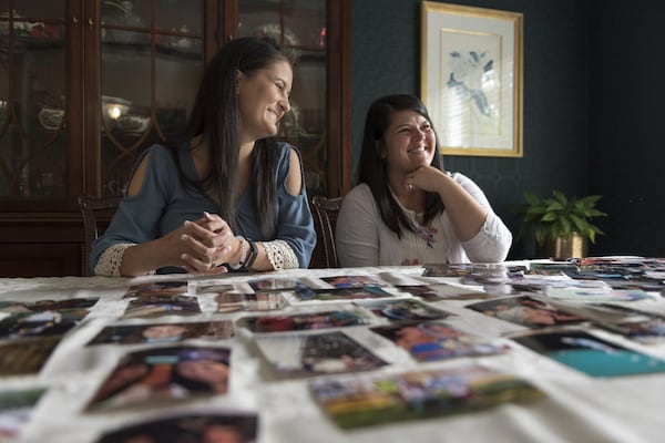 Amy Damera (left), 26, and Katalina Jones, 32, smile to each other during a May 5 interview in Gainesville. Damera and Jones were each put up for adoption in Romania as children but didn’t find each other until recently. The sisters, with Damera’s husband, are planning a trip to meet their Romanian family. DAVID BARNES / DAVID.BARNES@AJC.COM