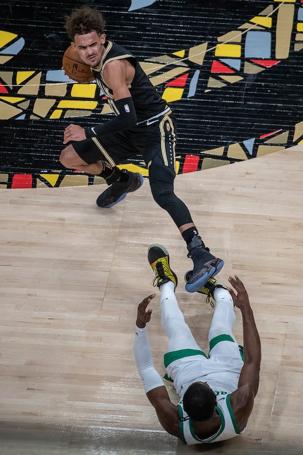 Hawks guard Trae Young (11) falls as he gains possession of the ball that Boston Celtics guard Jaylen Brown (7) tried to take from him during the second quarter Wednesday, Feb. 24, 2021, at State Farm Arena in Atlanta. (Alyssa Pointer / Alyssa.Pointer@ajc.com)