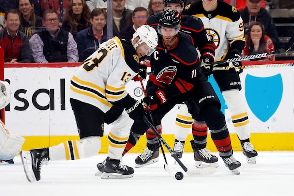 Carolina Hurricanes' Jordan Staal (11) battles for the puck with Boston Bruins' Charlie Coyle (13) during the first period of an NHL hockey game in Raleigh, N.C., Thursday, March 6, 2025. (AP Photo/Karl DeBlaker)