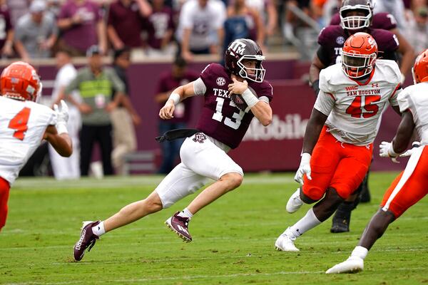 Texas A&M quarterback Haynes King (13) runs for a first down as Sam Houston State's Tyler Moore (45) defends the first half of an NCAA college football game Saturday, Sept. 3, 2022, in College Station, Texas. (AP Photo/David J. Phillip)