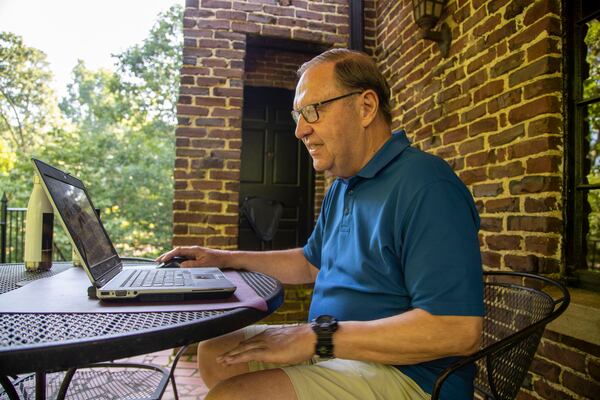 Steve Rushing sits at a table on his front porch that he converted into his office space at his residence in Decatur, Tuesday, June 15, 2021. (Alyssa Pointer / Alyssa.Pointer@ajc.com)