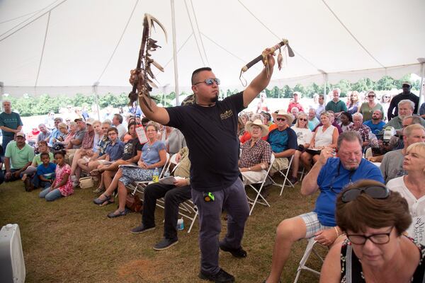 Juan Carlos holds up an item that is being auctioned off  at the  85-acre McIver ranch  before the start of the auction Aug. 4, 2018. (Photo: STEVE SCHAEFER / SPECIAL TO THE AJC)