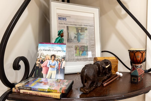 Tyler Perry movies and a framed Atlanta Journal-Constitution article are seen in the Dorothy and George Williams’ newly rebuilt home in Atlanta on Wednesday, December 4, 2024. The pair were displaced after falling victim to a home repair scam, but are back after filmmaker Tyler Perry offered to pay for construction. (Arvin Temkar / AJC)