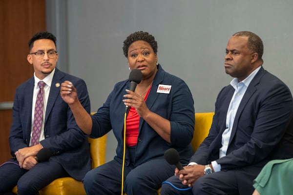 Atlanta mayoral candidates Antonio Brown (left) and Kasim Reed (right) listen as City Council President Felicia Moore speaks during a forum hosted by Partners for HOME and Policing Alternatives & Diversion Initiative on Friday, Oct. 1. (Alyssa Pointer/Atlanta Journal Constitution)