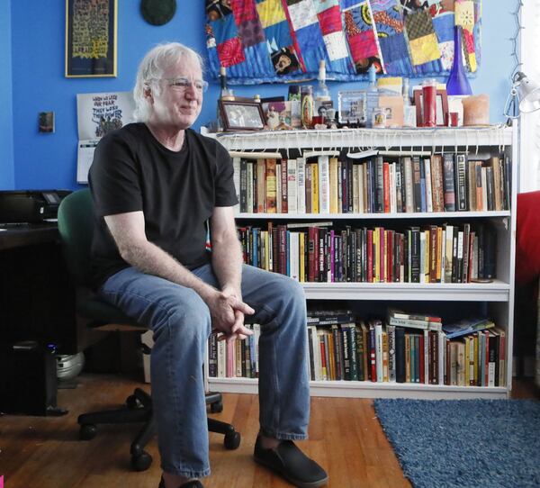 Paul McLennan sits in the room that contains his book collection and other possessions in the Decatur house he shares with his wife. BOB ANDRES / BANDRES@AJC.COM