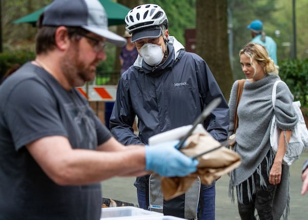 Walter Brown (C) orders fresh bread at the Carter Center Farmers Market Saturday, March 28, 2020. STEVE SCHAEFER / SPECIAL TO THE AJC