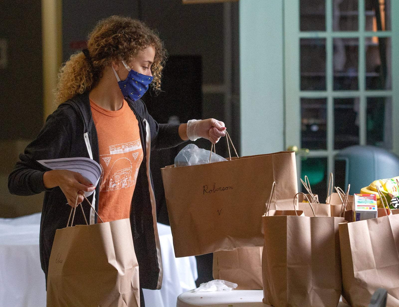 Concrete Jungle volunteer Cecelia Borgman organizes the meals that will be delivered to Atlanta needy families Monday, April 20, 2020. STEVE SCHAEFER / SPECIAL TO THE AJC