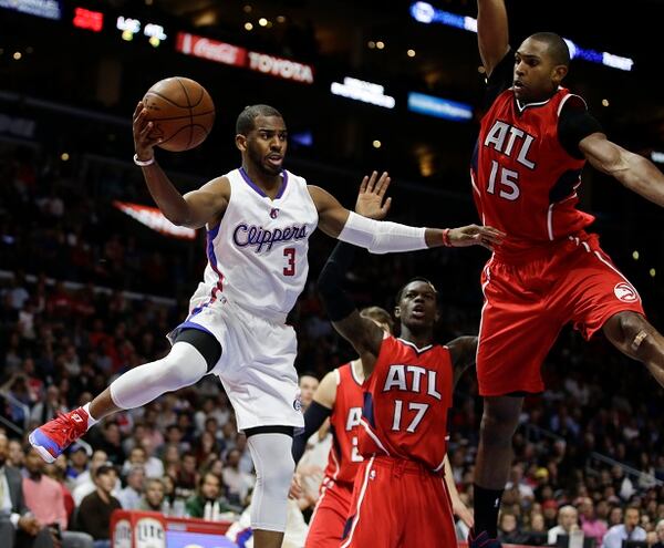 Los Angeles Clippers guard Chris Paul, left, passes around Atlanta Hawks center Al Horford during the second half of an NBA basketball game in Los Angeles, Monday, Jan. 5, 2015. The Hawks won 107-98. (AP Photo/Chris Carlson) The famous Chris Paul is outnumbered by Hawks. (Chris Carlson/AP photo)