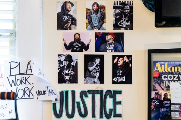 Printed photos of celebrities wearing Cruvie Clothing apparel are displayed on the wall of Cruvie Clothing founder Tony Cruver’s home workspace in West End in Atlanta. (Seeger Gray / AJC)