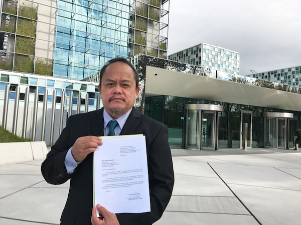 FILE- Lawyer Jude Sabio from the Philippines stands for a photo as he holds a 77-page file outside the International Criminal Court asking to investigate his country's president Rodrigo Duterte for crimes against humanity, in The Hague, Netherlands, Monday, April 24, 2017. (AP Photo/Mike Corder, File)