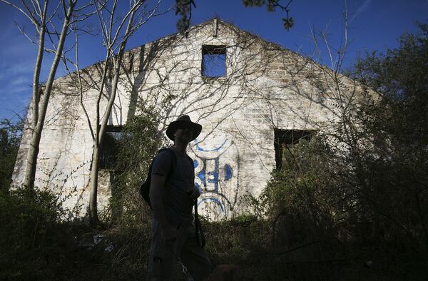 Joe Peery walks past a dilapidated building at the old Atlanta Prison Farm east of Atlanta. (PHOTO BY PHIL SKINNER/SPECIAL)