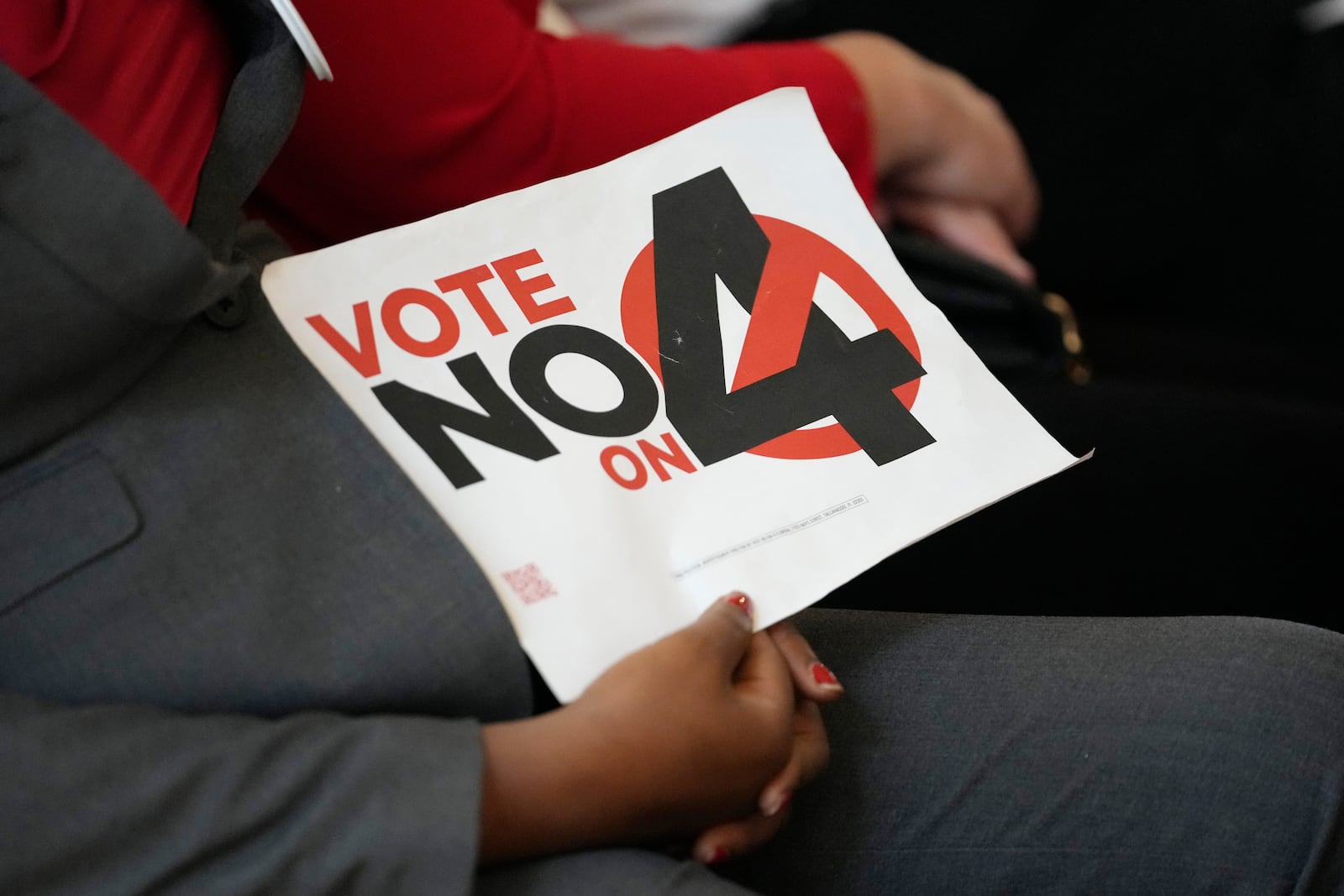 A person in the audience holds a sign against Amendment 4 which would protect access to abortion as Florida Gov. Ron DeSantis speaks during a news conference with Florida Physicians Against Amendment 4 Monday, Oct. 21, 2024, in Coral Gables, Fla. (AP Photo/Lynne Sladky)