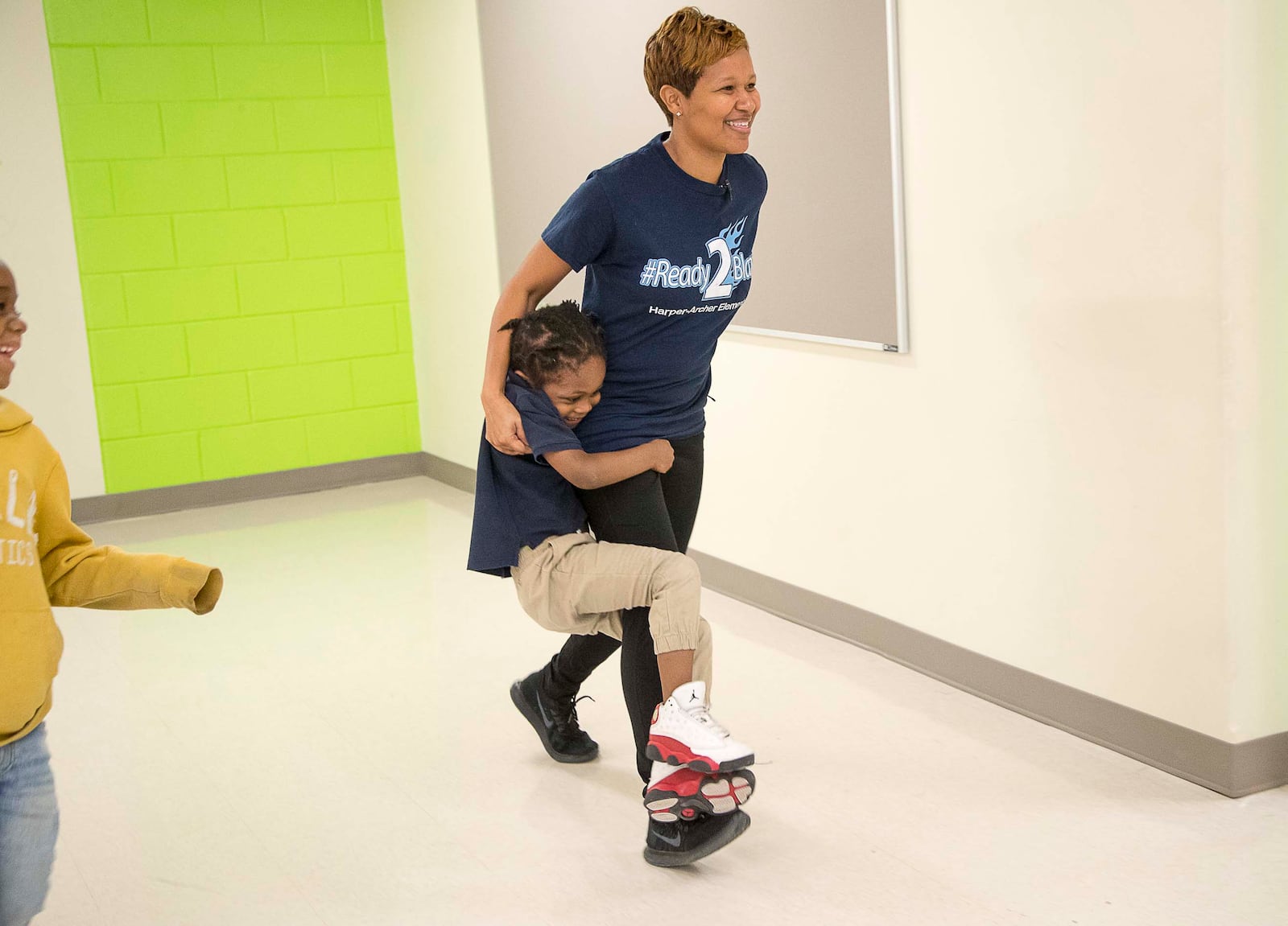 Harper-Archer Elementary School kindergartner Major Thomspon holds onto the leg of the school's dance teacher, Lisa Perrymond, as they make their way to the dance studio for their class, Tuesday, January 28, 2020. Perrymond sees her students once a week for a 45 minute class. (ALYSSA POINTER/ALYSSA.POINTER@AJC.COM)