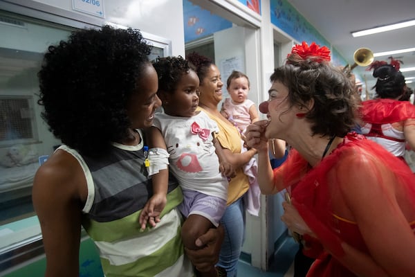 Young patients watch a clown from the "Roda de Palhacos" cultural project during a carnival party at the pediatric area of the Servidores do Estado Federal Hospital in Rio de Janeiro, Tuesday, March 11, 2025. (AP Photo/Bruna Prado)