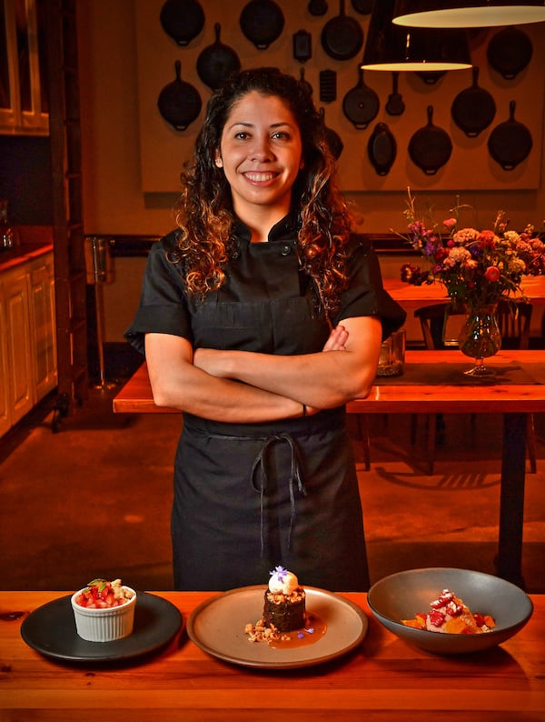 Pastry chef Claudia Martinez of Miller Union, with her desserts: (from left) Meyer Lemon Semifreddo With Oat Cookie Crumble and Macerated Strawberries, Gluten-Free Chocolate Cake With Salted Caramel and Candied Hazelnuts, and Raspberry Cheesecake Mousse With Pretzel Crunch. (Styling by Claudia Martinez / Chris Hunt for the AJC)