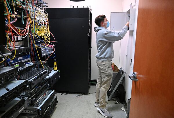 Ethan King, technician with Compass Security Solutions, checks the main alarm panel at a car dealership in Sandy Springs on Thursday, April 22, 2021. (Hyosub Shin / Hyosub.Shin@ajc.com)