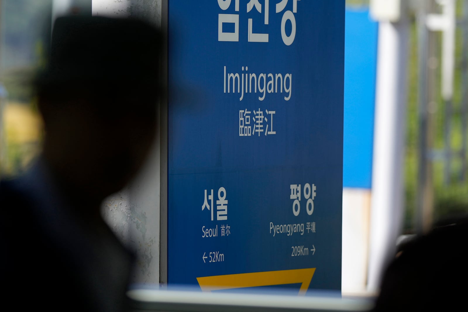 A visitor walks past a signboard showing the distance to North Korea's capital Pyongyang and to South Korea's capital Seoul from Imjingang Station in Paju, South Korea, Wednesday, Oct. 9, 2024. (AP Photo/Lee Jin-man)