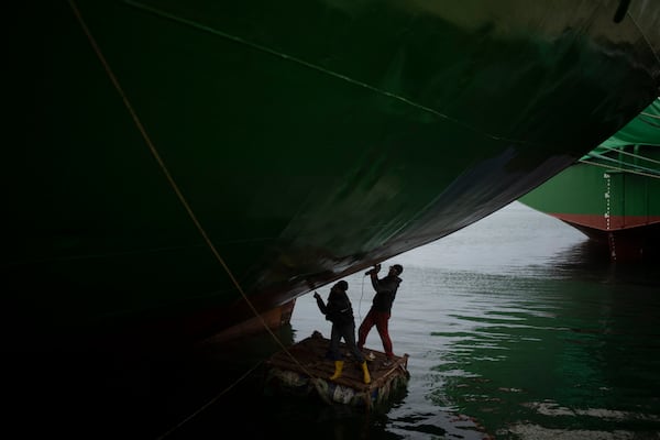 Men work on a cargo ship docked at a terminal of the port of Latakia, Syria, Monday, Dec. 16, 2024. (AP Photo/Leo Correa)