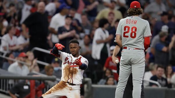 Ozzie Albies of the Braves celebrates beside Phillies third baseman Alec Bohm after hitting a triple in the fourth inning of a baseball game Saturday, May 8, 2021, in Atlanta.