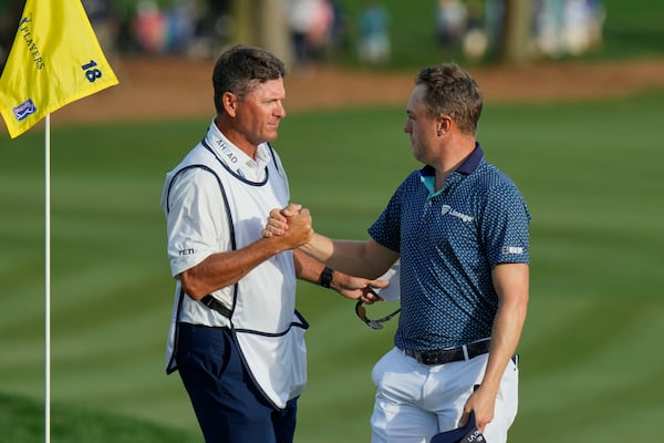 Justin Thomas, right, shakes hands with his caddie Matt Minister on the 18th green after shooting a 62, tying the course record, during the second round of The Players Championship golf tournament Friday, March 14, 2025, in Ponte Vedra Beach, Fla. (AP Photo/Chris O'Meara)