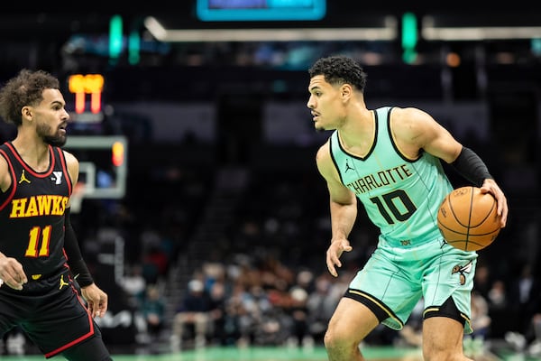 Charlotte Hornets guard Josh Green (10) brings the ball up court against Atlanta Hawks guard Trae Young (11) during the first half of an NBA basketball game, Saturday, Nov. 30, 2024, in Charlotte, N.C. (AP Photo/Matt Kelley)