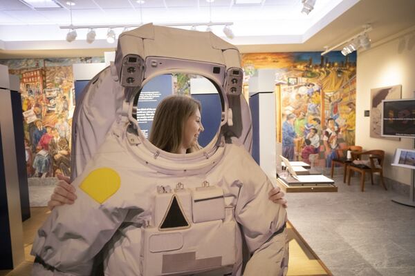 Sarah Anderson is curator of an exhibit at the University of Georgia's Richard B. Russell Special Collections Building celebrating the 50th anniversary of the moon landing and Sen. Russell's role in the space program. She places a space suit on display. Russell wasn't the only Georgian who contributed to the space race. COURTESY UNIVERSITY OF GEORGIA