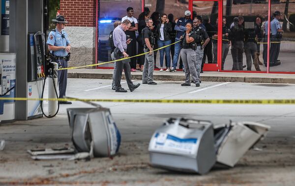 Investigators collect evidence after a man was shot and killed by Conyers police at a gas station Wednesday.