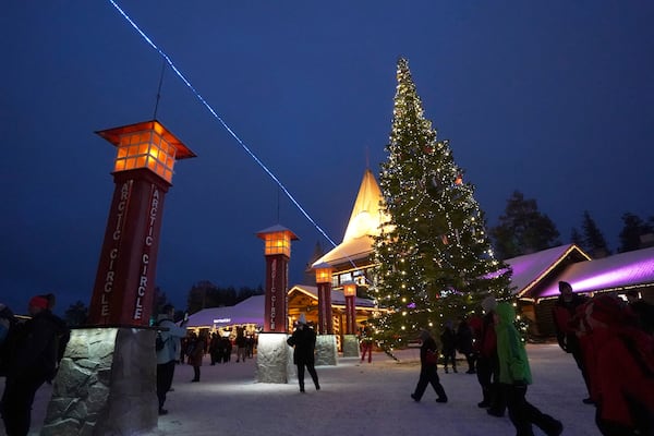 Tourists visit Santa Claus Village, a winter-themed amusement park perched on the edge of the Arctic Circle, in Rovaniemi, Finland, Wednesday, Dec. 4, 2024. (AP Photo/James Brooks)