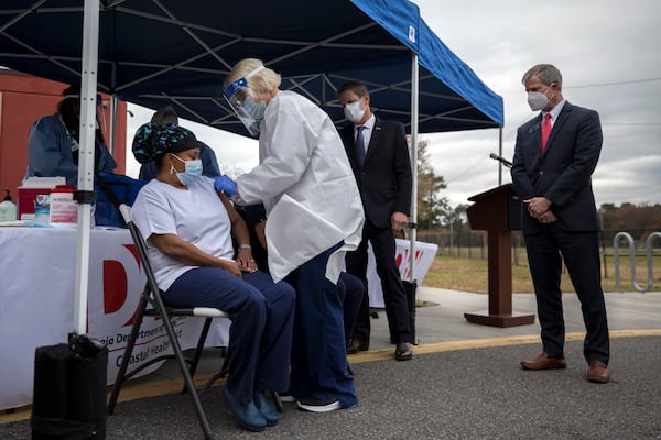 State Sen. Ben Watson, right, watches one of the first inoculations of the Pfizer-BioNTech COVID-19 vaccine given to healthcare workers in Savannah on Tuesday. (AJC Photo/Stephen B. Morton)
