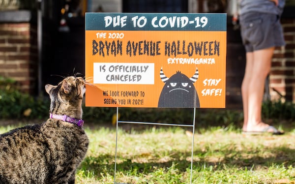 The East Point neighborhood around Bryan Avenue replaces Halloween decorations with yard signs announcing the 2020 extravaganza is canceled.  Mr. Tiddles, a mainstay on Bryan Avenue, comes out to show support. Jenni Girtman for The AJC