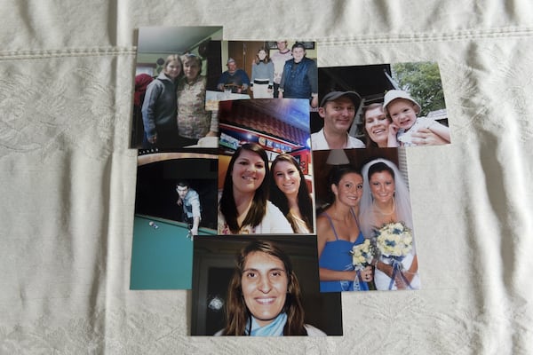 Photographs of Amy Damera’s and Katalina Jones’ families are posed on a table in Gainesville on May 5. Damera and Jones were each put up for adoption in Romania as children. When separate families took them in, the two didn’t know about each other. Damera’s and Jones’ paths almost crossed numerous times before they discovered that they lived within miles of each other. DAVID BARNES / DAVID.BARNES@AJC.COM