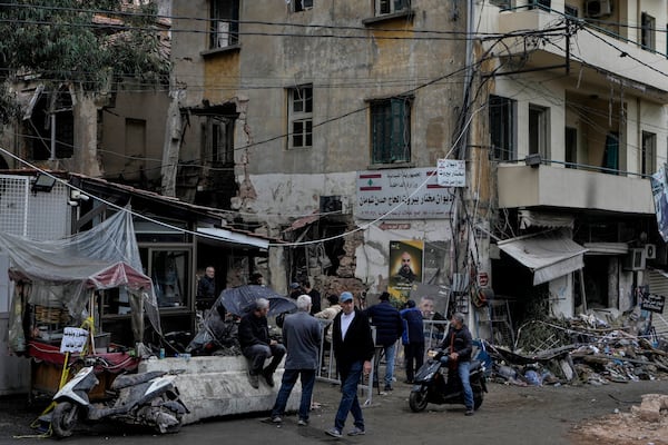 People stand next to a destroyed building hit on Monday evening by an Israeli airstrike in central Beirut, Lebanon, Tuesday, Nov. 19, 2024. (AP Photo/Bilal Hussein)