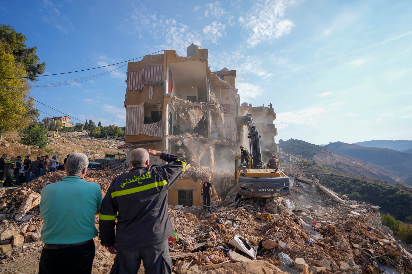 Rescue workers use excavators to remove the rubble of a destroyed building that was hit Tuesday night in an Israeli airstrike, as they search for victims in Barja, Lebanon, Wednesday, Nov. 6, 2024. (AP Photo/Hassan Ammar)