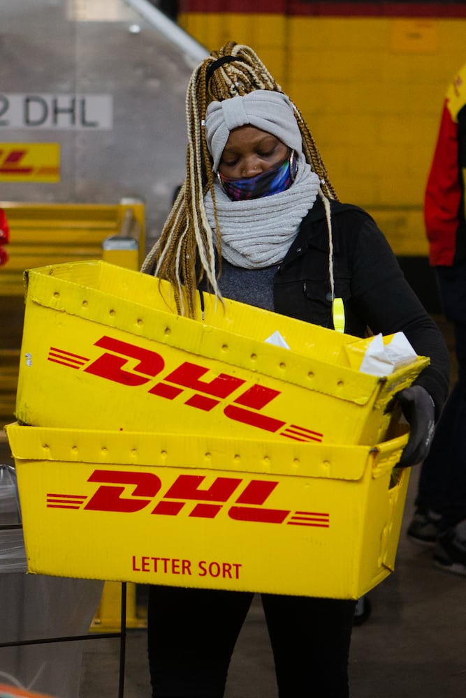 Shamika Thomas sorts packages on Wednesday, December 16, 2020, at DHL Express in Atlanta. Workers at the shipping center worked to fulfill orders during the holiday rush. CHRISTINA MATACOTTA FOR THE ATLANTA JOURNAL-CONSTITUTION.