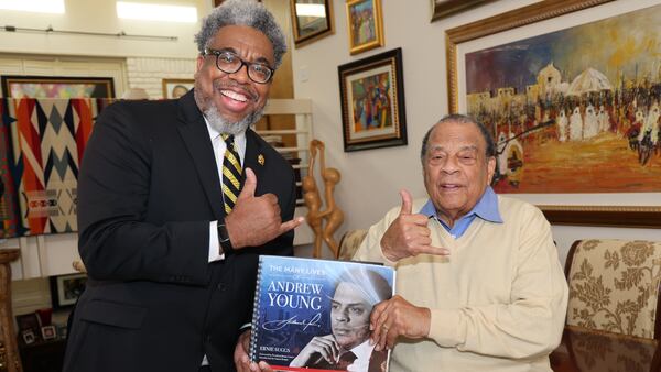 Author and Atlanta Journal-Constitution reporter Ernie Suggs and Ambassador Andrew Young flash the Alpha Phi Alpha Fraternity sign while holding a copy of the new book, "The Many Lives of Andrew Young." (Tyson A. Horne / tyson.horne@ajc.com)